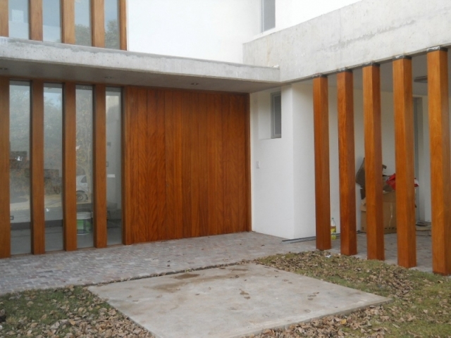 Puerta machiembrada vertical y columnas en madera de Okumé