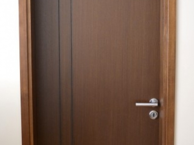 Puerta placa enchapada en Wengue con buñas verticales
